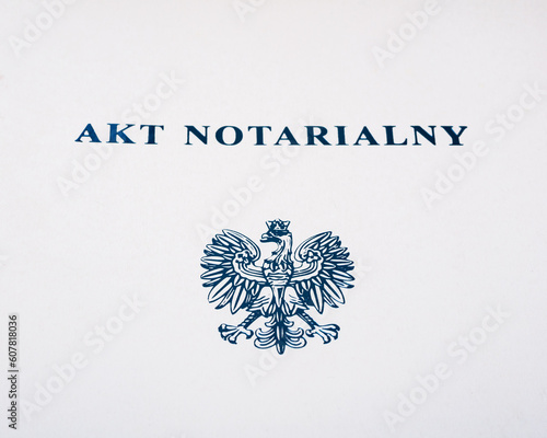 Zbliżenie na napis na teczce" akt notarialny" oraz orzełka 
