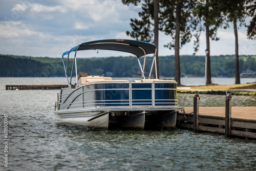 Pontoon boat at private dock on freshwater lake.