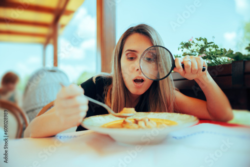 Picky Eater Inspecting Soup with Magnifying Glass. Perfectionist woman checking her meal for any wrong details 