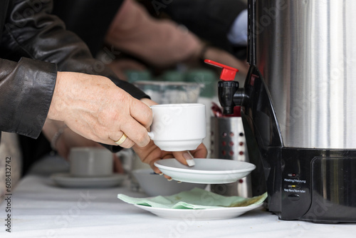 Frau füllt am Buffet Kaffee in eine Tasse