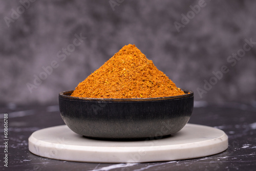 Cajun spice powder on dark background. Powdered dried cajun in bowl