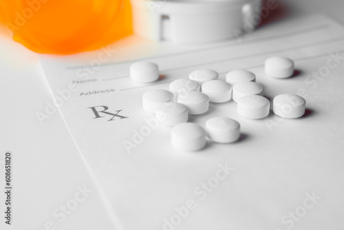 white prescription pills laying on rx pad on white background