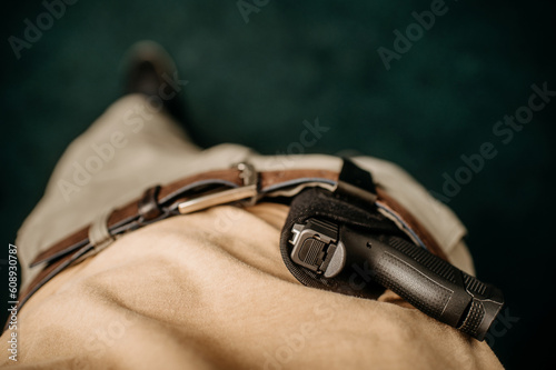 a concealed weapon in a holster behind his belt,