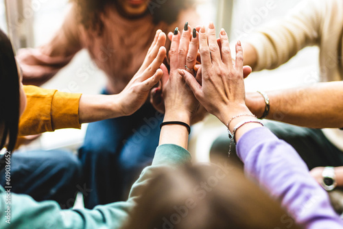 Young multiracial group stacking hands together- Happy diverse friends united at community table having fun- youth Millennial students giving strength motivation- Human resources teamwork concept 