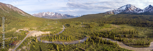 Panoramic scenic area in wilderness of Yukon Territory, Canada during summer time with boreal forest, winding river and snow capped mountains. 
