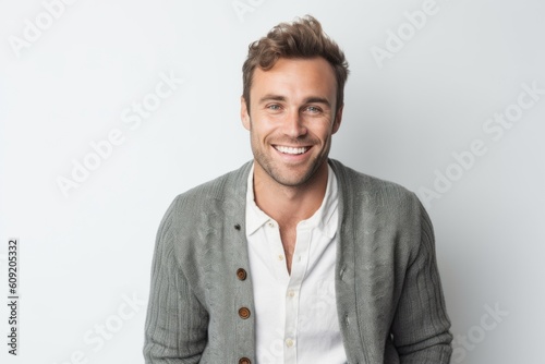 Portrait of handsome man smiling at camera while standing against white background