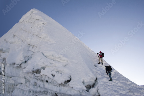 Two climbers about to summit Island Peak in Nepal. The peak is very close to Everest and Lhotse. This picture was taken in in the middle of October at 6:45am.