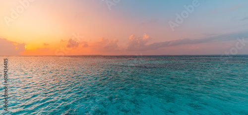 Calm sea with sunset sky and sun through the clouds over. Meditation ocean and sky background. Tranquil seascape. Horizon relaxing bright waves, crystal clear pristine ocean bay. Sunrise dream beach