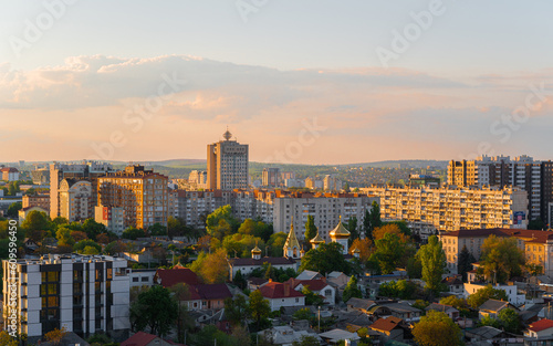 Church between skyscrapers. City landscape. Orthodox church with golden rooftop. Sunrise. Chisinau downtown, capital of Moldova. Golden domes.