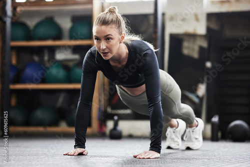 Fitness, push up and woman in gym for exercise, bodybuilder training and strong muscles. Healthy body, sports center and female person do pushup on floor for wellness, performance and cardio workout