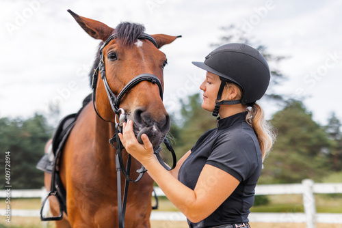 Female rider hand gently caressing beautiful thick red horse mane, close up shot. Equitation and animal lover concept.
