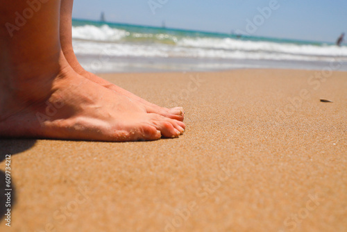 Pies de mujer sexy sobre la arena de la playa