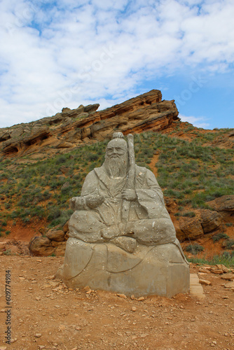 Statue of the White Elder against summer mountain landscape in Bogdo Baskunchak Nature Reserve.