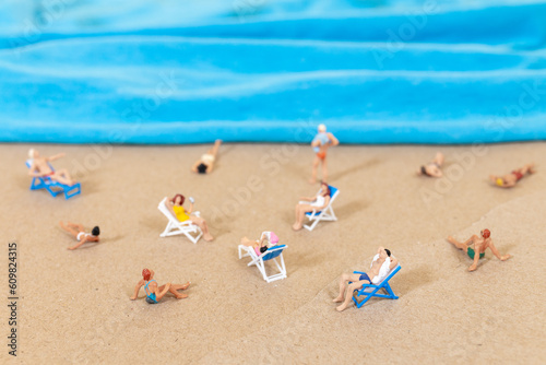A tiny person in a swimsuit is relaxing on the beach in the summer