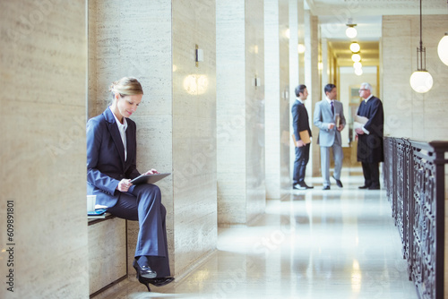 Lawyer working on digital tablet in courthouse