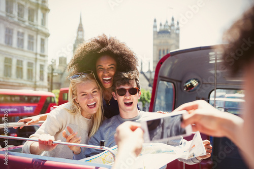 Enthusiastic friends being photographed on double-decker bus