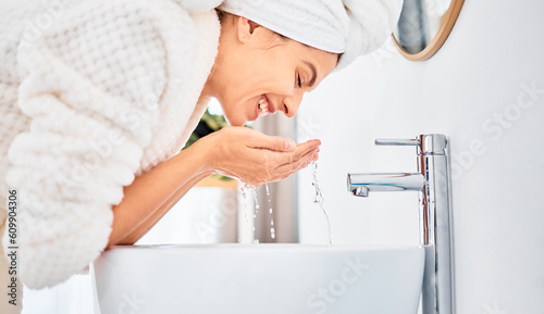 Water splash, skincare and happy woman washing her face in a bathroom for beauty, hygiene and wellness. Facial, cleaning and female with drops for dermatology and cleansing treatment in her home