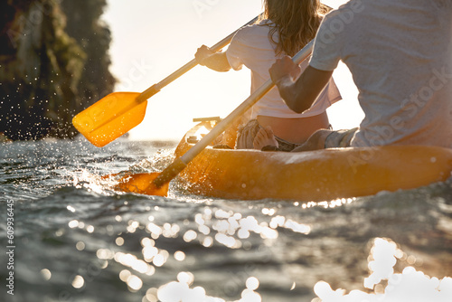 Close up photo of kayaking couple at sunset sea