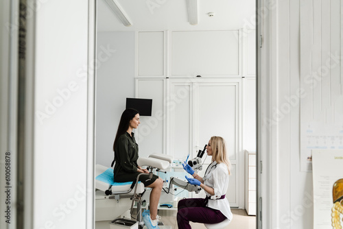 Gynecologist is holding speculum for colposcopy procedure to closely examine cervix, vagina and vulva of girl in gynecology clinic.