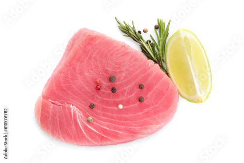 Raw tuna fillet with spices and lime wedge on white background, top view