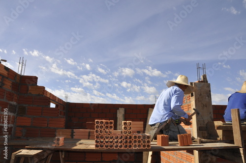 pedreiro construtor edificando parede de tijolos em obra 