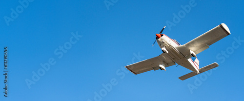 Small white cessna single propeller plane flying in a clear blue sky maneuvering before landing at Sabadell airport