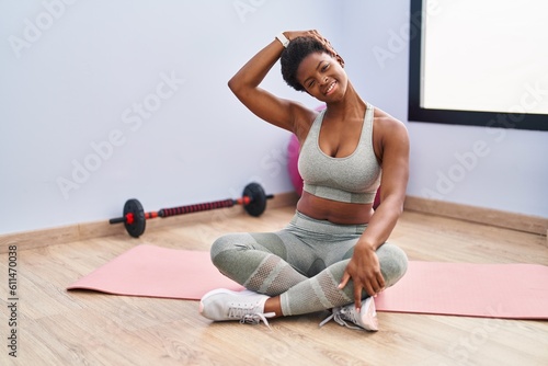 African american woman smiling confident stretching neck at sport center