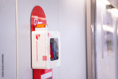 Automatic external defibrillator mounted on white wall
