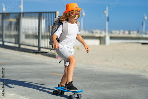 Summer sport kids with skateboard. Child riding skateboard in the road. Kid practicing skateboard. Children learn to ride skateboard in a park on sunny summer day. Kid skating on skateboards.