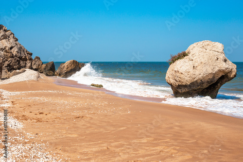 Seascape. Sea coast with rocks and stone, washed by a wave