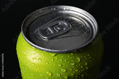 Green can of fresh soda with water drops on dark background, closeup