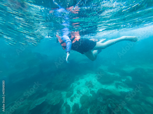 Young woman snorkeling scuba diving with life jacket at the Great Barrier Reef in the tropical 