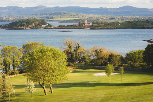 Scenic view of coastal golf hole and green and the Firth of Forth with the historic Inchcolm Abbey and the Pentland Hills from Fife, Scotland.