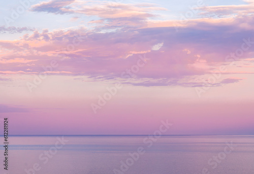 scenic blue seascape of sunset or sunrise above water with beautiful colorful evening clouds, deep blue rain clouds, natural weather concept