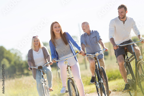 Happy family bike riding in sunny field