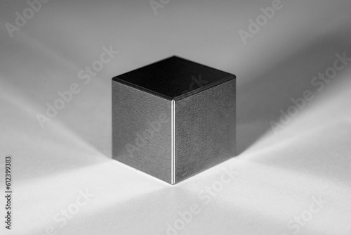 A tungsten cube with reflections and shadows against a white background