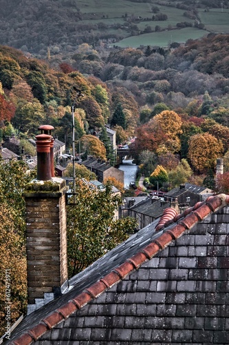 Vertical shot of Hebden Bridge market-town with old buildings surrounded by autumn trees