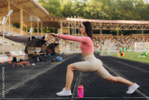 young woman warms up before jogging on stadium, People sport and fitness concept.
