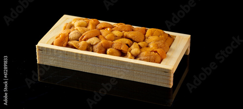 Bafun urchin or uni in wooden box on dark background, Uni sushi or sashimi ingredients, Japanese style