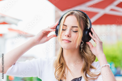 portrait of a relaxed woman meditating listening audio guide with wireless headphones in a park