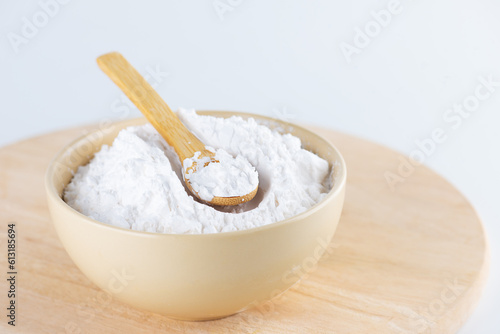 Tapioca starch in a bowl on a wooden board, light background.