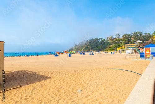 The morning fog lifts at the wide, sandy Playa Grande beach at the Spanish resort town of Lloret de Mar, on the Costa Brava coast. 
