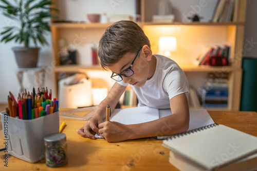 young boy child kid pupil study work on homework assignment at home