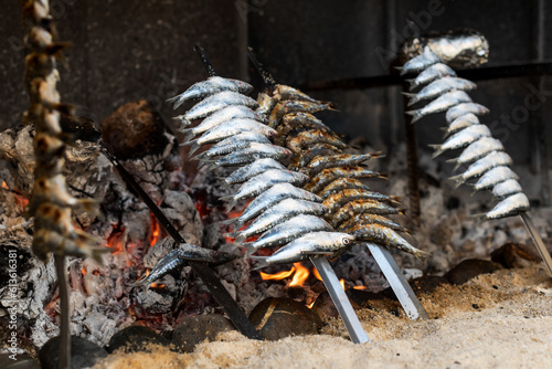Close-up of sardine "espetos" (sardine skewers) being cooked next to the embers. Typical food from Malaga in the south of Spain