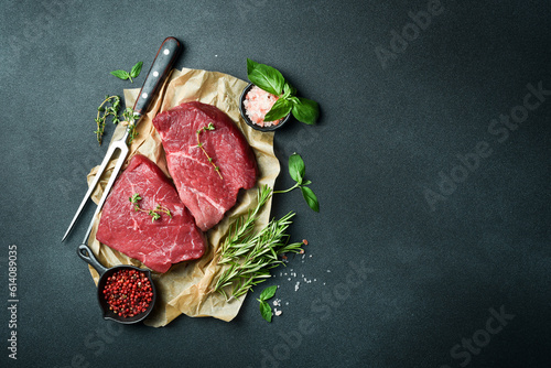 Juicy raw veal with steak spices on a stone background. Veal, meat. Top view.