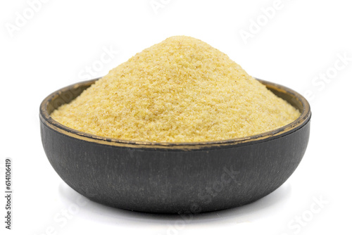 Dry organic semolina flour isolated on white background. Uncooked organic semolina in bowl. Close up