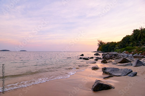 Beautiful landscape with colorful sunset on the sea rock beach.