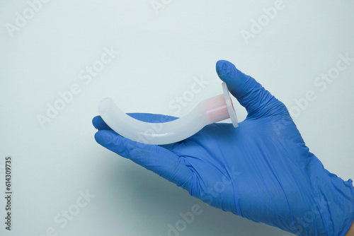 Medical worker wearing medical gloves holding an OPA (Oropharyngeal airway) is a medical device called an airway adjunct that is used in airway management to maintain or open a patient's airway