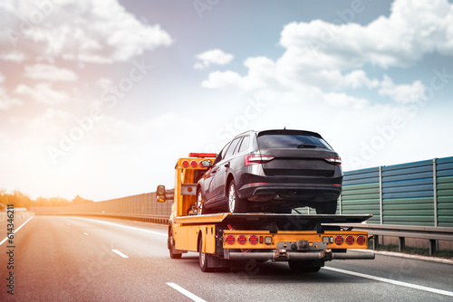 Reliable Towing and Recovery Services: 24/7 Assistance for Vehicle Breakdowns and Accidents. Emergency roadside assistance on the highway. side view of the flatbed tow truck with a damaged vehicle