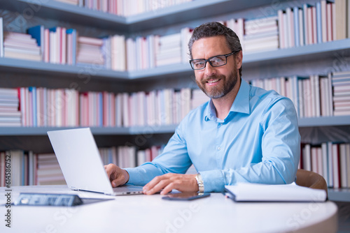 Portrait of teacher with book in library classroom. Handsome teacher in university. Teachers Day. Good school teacher. Tutor at college. Man with books in library. Knowledge and education concept.